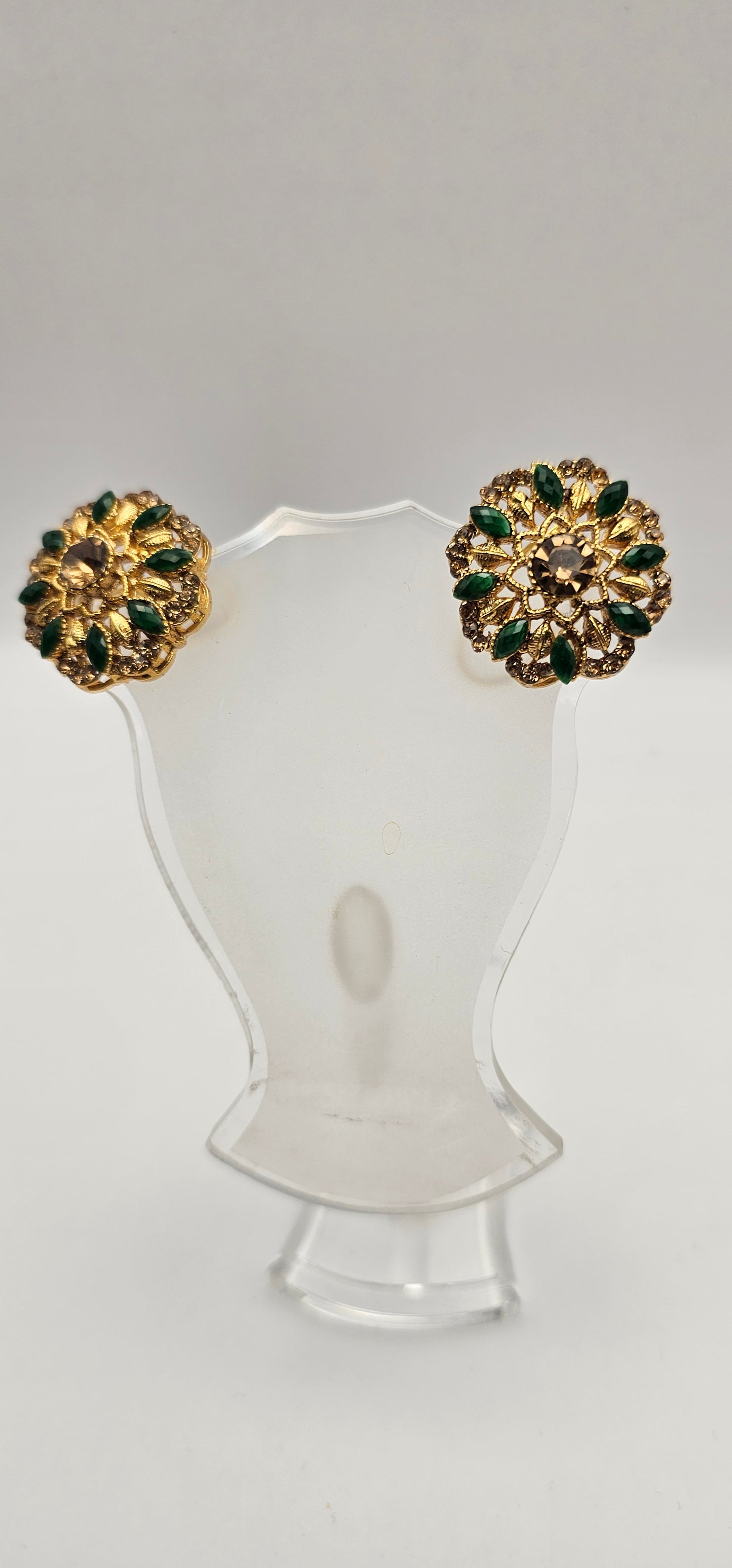 Pair of earrings from Villandi comes together with a beautifully delicate floral pattern, decorated with an interplay of green Emeralds