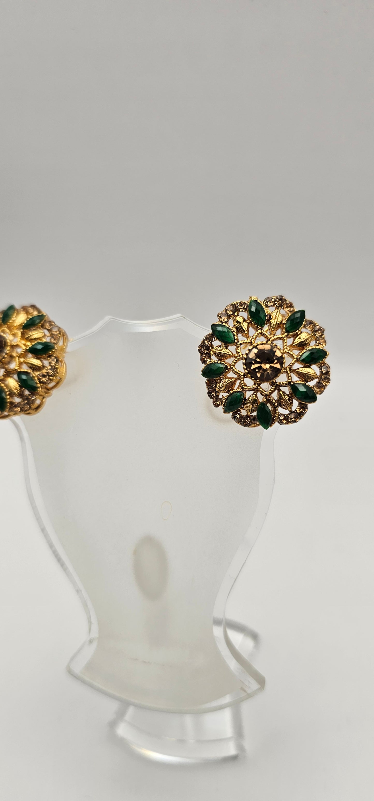 Pair of earrings from Villandi comes together with a beautifully delicate floral pattern, decorated with an interplay of green Emeralds