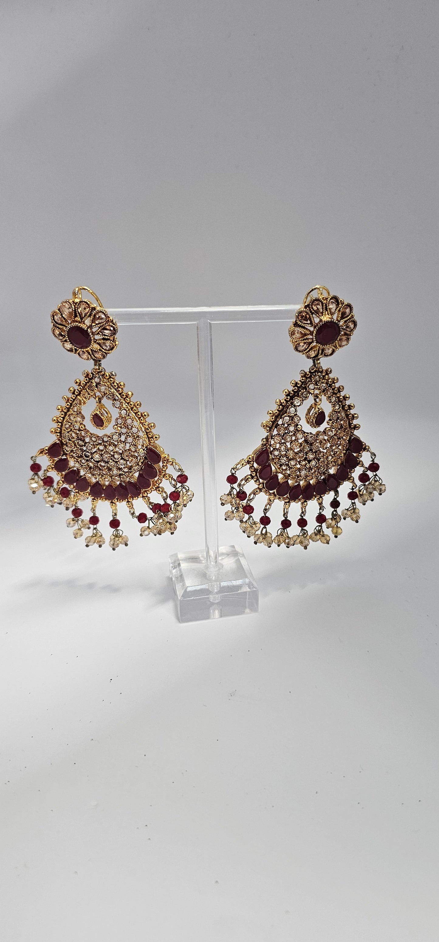 Premium quality chandbali earrings, adorned with semi precious ruby and emerald stones and finished off with Gold foiled kundans.
18kt gold plated.