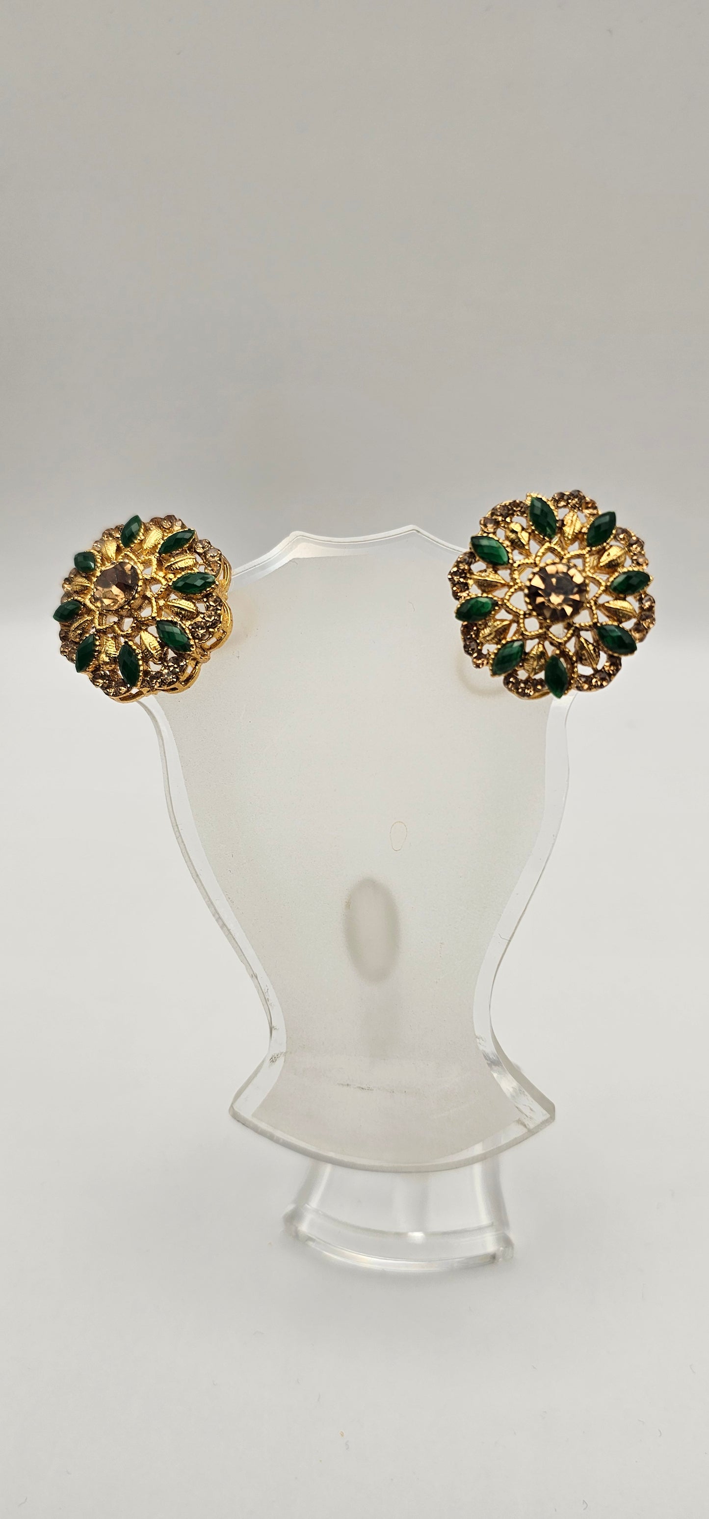 Pair of earrings from Villandi comes together with a beautifully delicate floral pattern, decorated with an interplay of green Emeralds