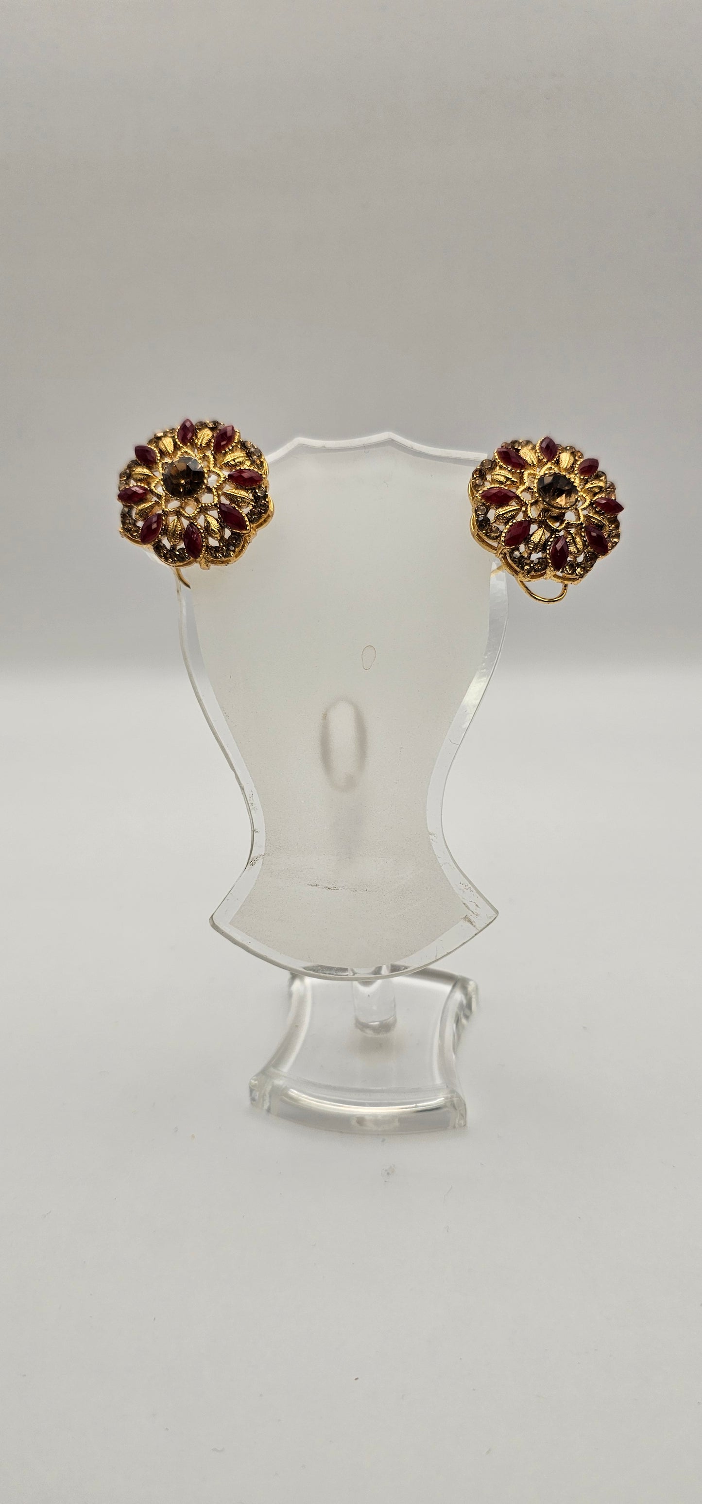 Pair of earrings from Villandi comes together with a beautifully delicate floral pattern, decorated with an interplay of rubies and diamonds