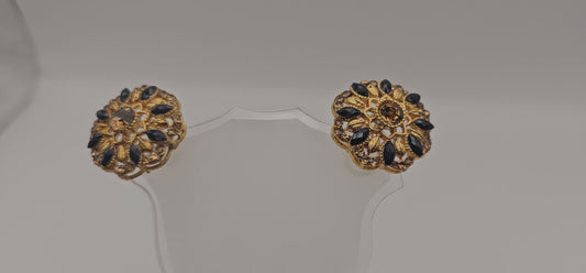Pair of earrings from Villandi comes together with a beautifully delicate floral pattern, decorated with an interplay of Navy & Gold