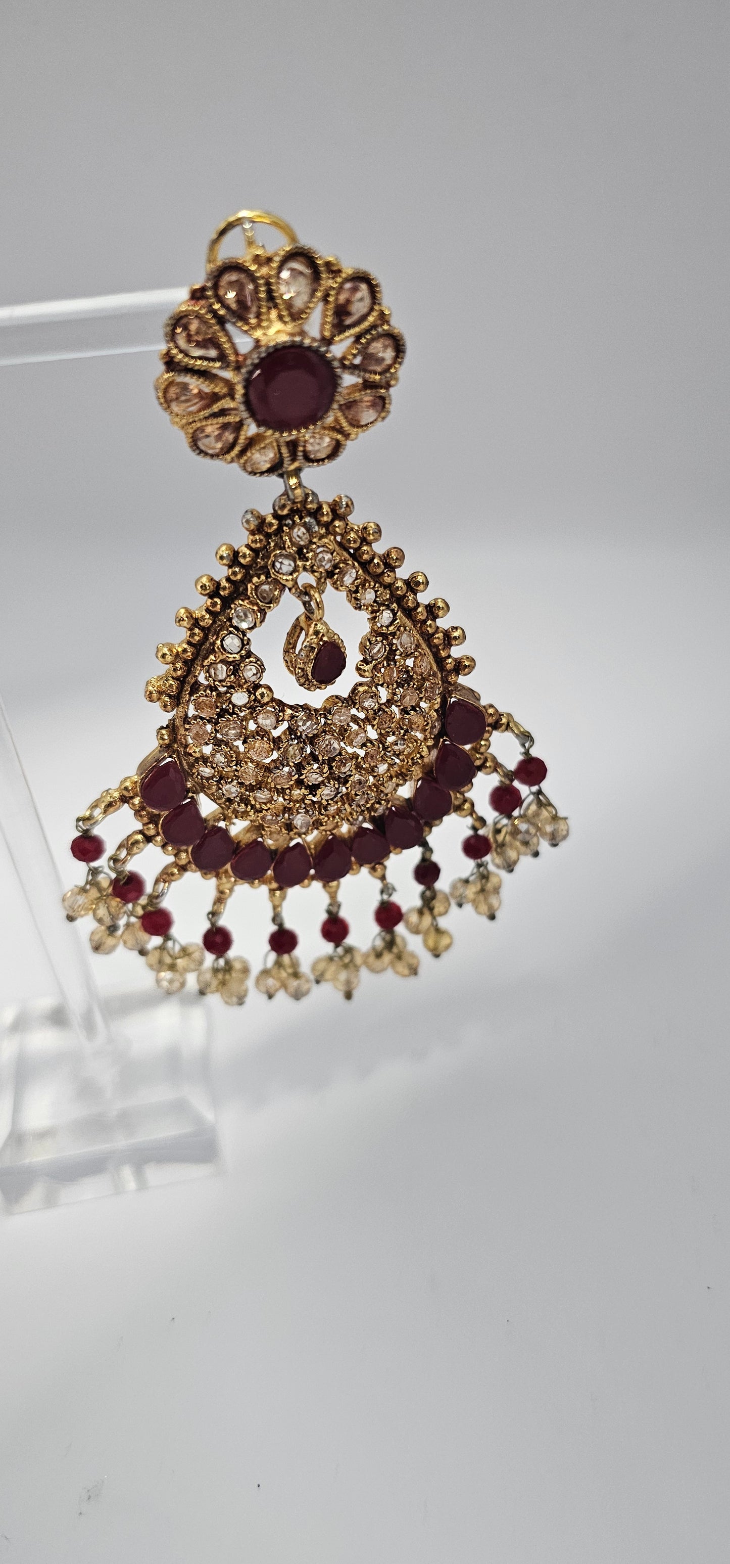 Premium quality chandbali earrings, adorned with semi precious ruby and emerald stones and finished off with Gold foiled kundans.

18kt gold plated.