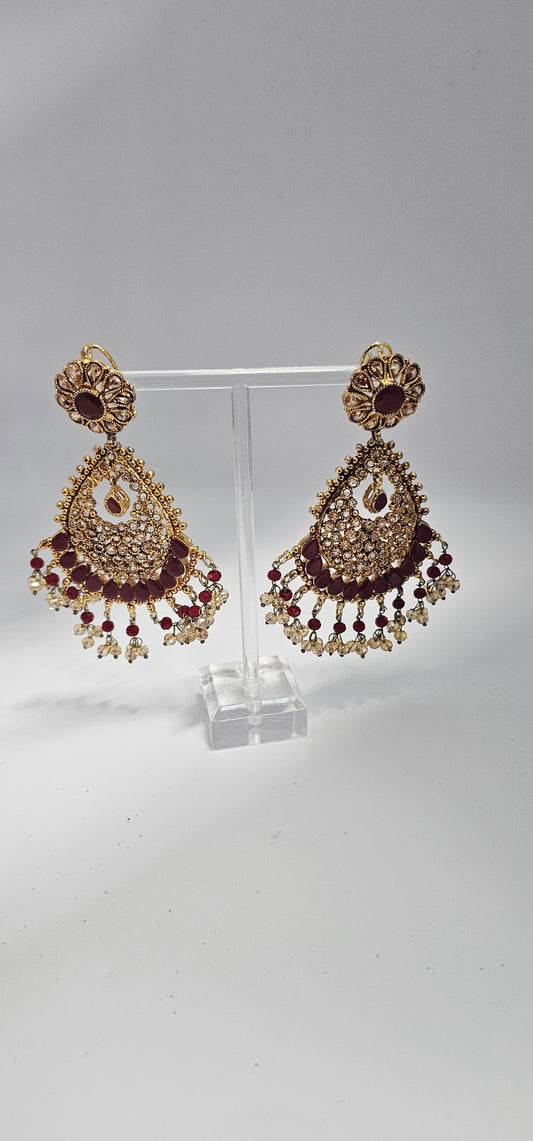 Premium quality chandbali earrings, adorned with semi precious ruby and emerald stones and finished off with Gold foiled kundans.

18kt gold plated.