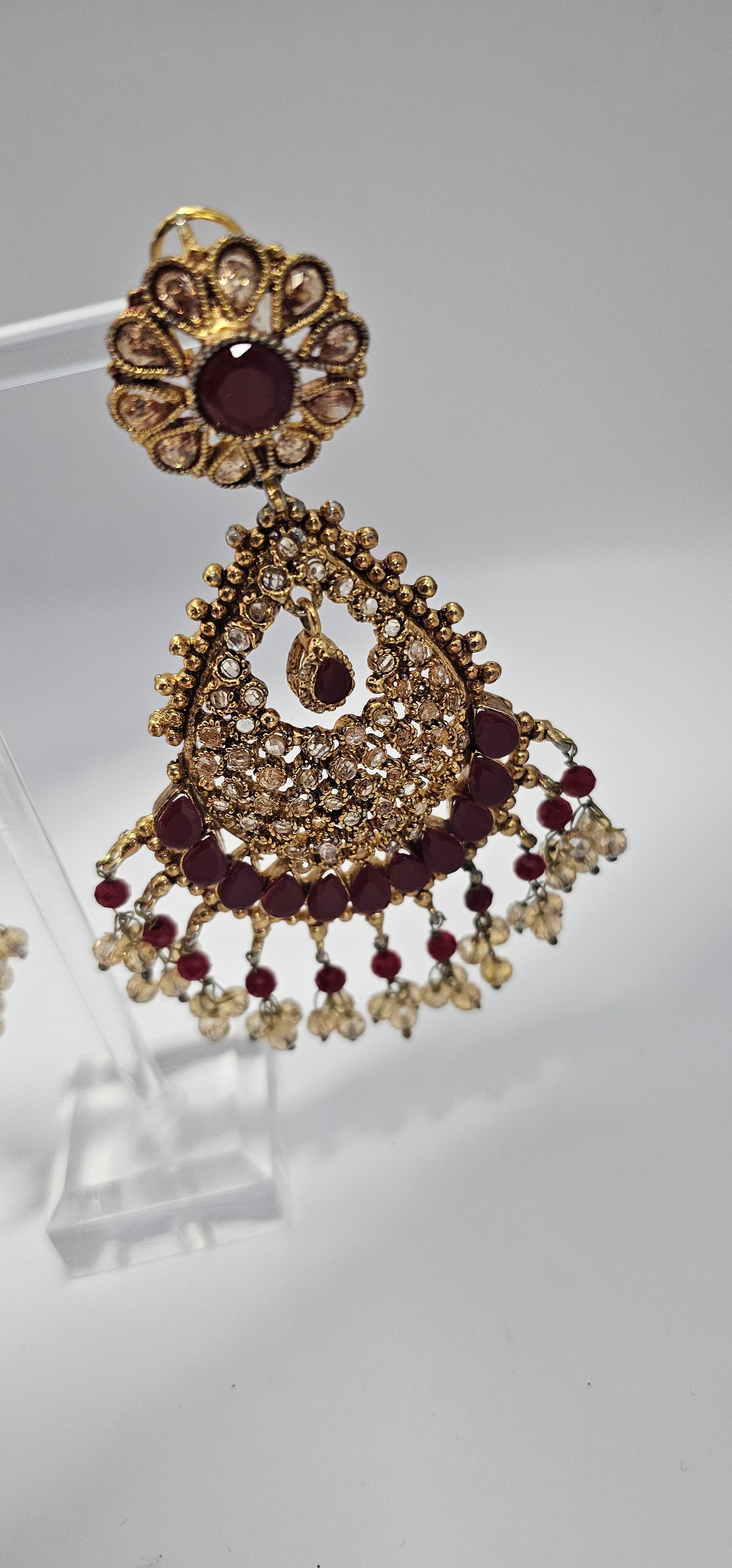 Premium quality chandbali earrings, adorned with semi precious ruby and emerald stones and finished off with Gold foiled kundans.

18kt gold plated.