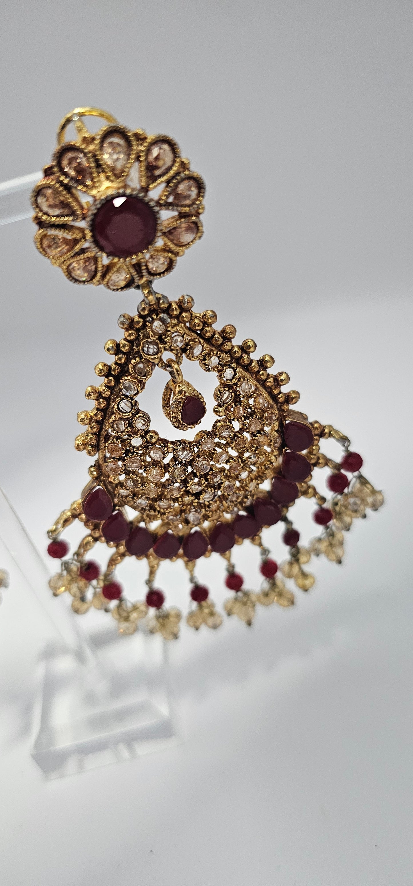 Premium quality chandbali earrings, adorned with semi precious ruby and emerald stones and finished off with Gold foiled kundans.

18kt gold plated.